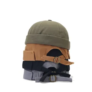 Detail view of stacked docker hats showing adjustable metal buckles and various colors.
