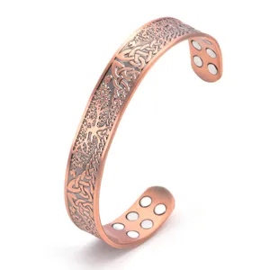 Detailed shot of copper magnetic bracelet with vintage tree of life engraving and embedded magnets.