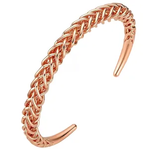 Close-up detail of the rose copper braided cuff bracelet, featuring woven metal and open ends.
