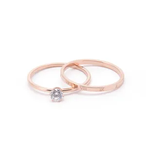 Detailed shot of double rose gold rings, one with solitaire diamond and one with Roman numerals.