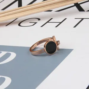 Titanium steel rose gold ring with black round acrylic charm and stylish T-bar detail for women.
