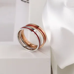 Minimalistische Edelstahl Stapelringe mit roter Emaillerille, elegantes Modeschmuck Detail.