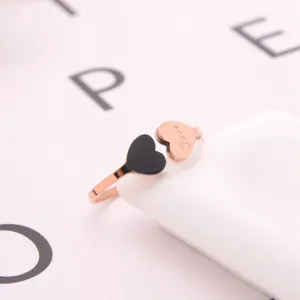Detail shot of the titanium steel open ring featuring a black acrylic and rose gold heart design.