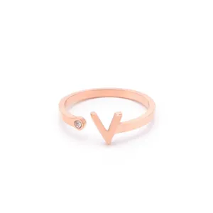 Close-up of a stylish rose gold open ring featuring a modern V-shape and sparkling stone detail.