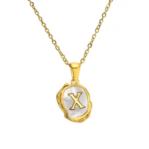 Golden stainless steel necklace featuring an irregular mother of pearl pendant with letter X.