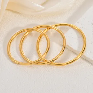 Gros plan des jonc dorés brossés de style rétro, élégant détail de bijoux en acier inoxydable.