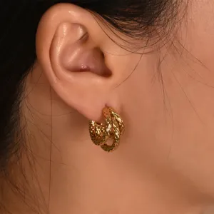 Detailed close-up shot of elegant intertwined gold hoop earrings with textured design.