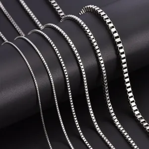 Close-up display of multiple silver-colored stainless steel box chains in varying widths.