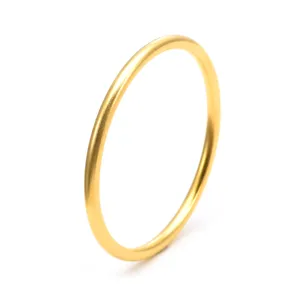 Gros plan d'un bracelet jonc doré brossé mat, mettant en valeur les détails de texture fine.