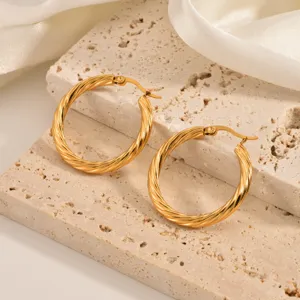 Exquisite twisted gold hoop earrings detail shot, minimalist design, elegant daily wear jewelry.