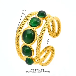 Gold stainless steel multi-layer open ring with green round resin stones. Detail view.