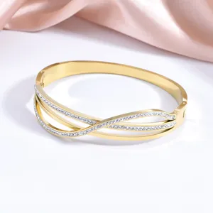 Detailed view of the gold-plated stainless steel crystal criss-cross bangle bracelet surface.