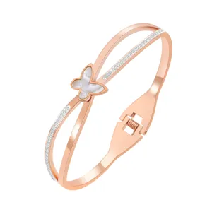 Bracelet jonc croisé en acier inoxydable doré rose avec papillon en coquille blanche et cristaux.