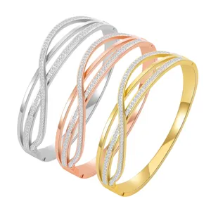 Detail view of multi-strand crossed crystal steel bangles in gold, silver, rose gold.