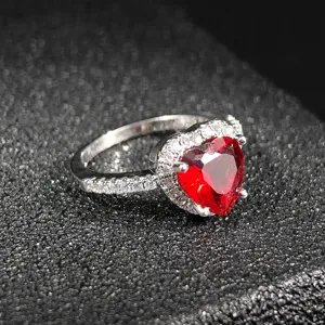 Stunning heart-shaped red gemstone ring with sparkling cubic zirconia halo pavé band.