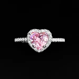 Detailed shot of a stunning pink heart-cut gemstone ring with sparkling pavé halo and band.