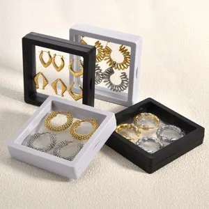 Close-up detail shot of transparent PE film jewelry storage boxes with gold and silver earrings.