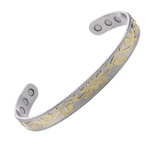 Detailed view of the open magnetic bangle bracelet featuring a two-tone floral vine relief.