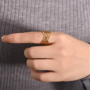 Close-up detail of the multi-layer crisscross open ring, showing the unique geometric gold lines.