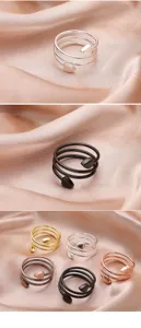 Vue détaillée de bagues de couple en spirale multicouche avec des embouts en forme de cœur.