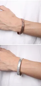 Detailed view of retro plum blossom carved magnetic copper and silver cuff bracelets.