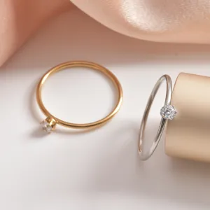 Close-up detail of minimalist single-stone cubic zirconia rings in elegant gold and silver finishes.