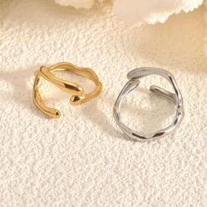 Close-up detail of geometric open rings in gold and silver, featuring a sleek niche design.