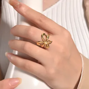 Detailed close-up view of the elegant gold open butterfly ring, showcasing its irregular curve.