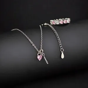 Vue détaillée du joli ensemble de bijoux collier et bague en zircone cœur avec pierres roses.