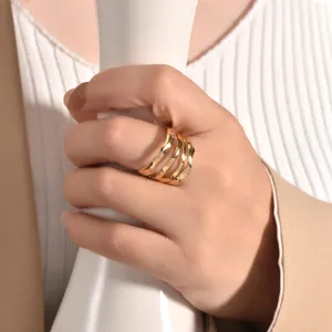 Detailed close-up of a multi-layer irregular wavy gold ring worn on a hand, minimalist style.