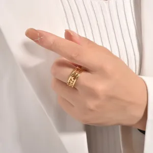 Close-up detail of gold stainless steel open ring with hollow star and moon design.