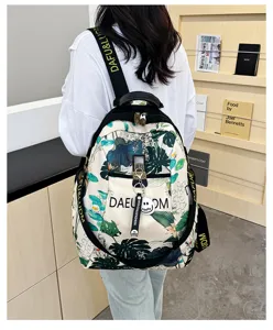 Detail view of stylish floral print oxford backpack with comfortable straps and cute charm pendant.