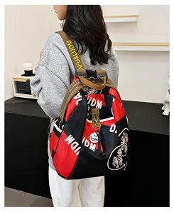 Detail view of the stylish colorblock canvas backpack worn by model with patterned straps.