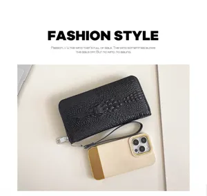 Gros plan du sac clutch long pour homme en motif crocodile noir avec dragonne pratique.