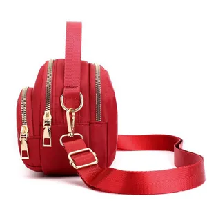Red nylon mini crossbody shoulder bag with multi zippers and gold hardware for daily use.