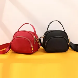 Mini nylon shell crossbody bag in red and black, lightweight detail view for commuting.