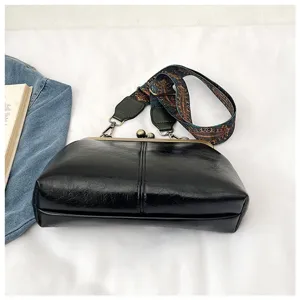 Detailweergave van zwarte PU lederen vintage kiss-lock schelp handtas met etnische riem.