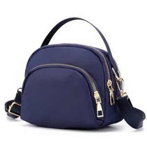 Mini nylon shell crossbody bag detail view, lightweight daily shoulder purse with gold zippers.