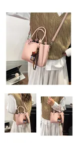 Pink leather shoulder bag for women, stylish crossbody handbag with cute bear pendant and top handle.