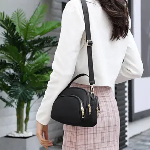 Black nylon mini crossbody bag with gold tone hardware, ideal for daily casual commute style.