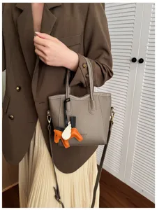 Piccola borsa secchiello in pelle con grazioso ciondolo cavallo alato e dettaglio tracolla.