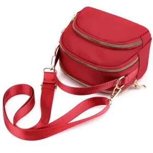 Red nylon mini crossbody bag detail showing multi zippers and adjustable strap for women