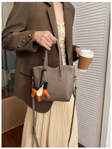 Primo piano dettagliato della borsa in vera pelle minimalista con ciondolo cavallo e finiture.