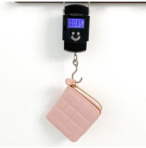 Détail de petit portefeuille rose matelassé, design à fermeture éclair, léger pour le quotidien.