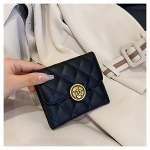 Gros plan sur le portefeuille court matelassé noir avec fermoir fleur de camélia élégant.