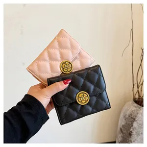 Gros plan de portefeuilles courts matelassés en noir et rose avec fermoir camélia chic.