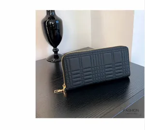 Black quilted long wallet detail shot showcasing detailed stitching and gold zipper hardware.