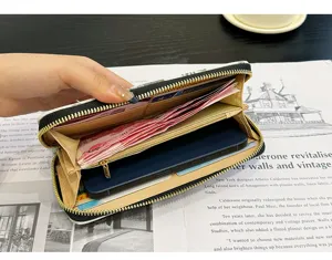 Vue rapprochée détaillée d'un long portefeuille zippé pour femme avec de nombreux fentes.