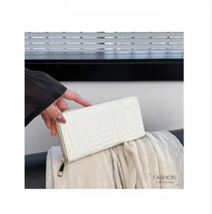 Detail view of a white long zip wallet featuring elegant embossed grid pattern texture.