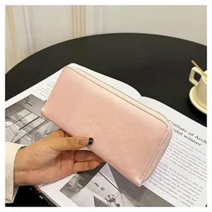 Dettaglio portafoglio lungo con zip rosa da donna, grande capacità con scomparti per carte.